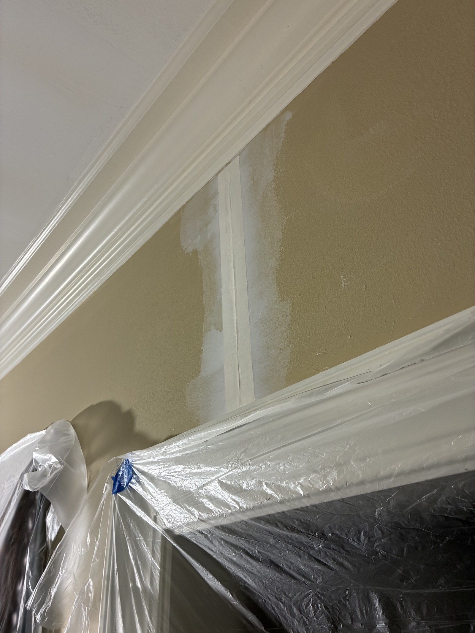 Drywall tape embedded in the first coat of joint compound above an interior door