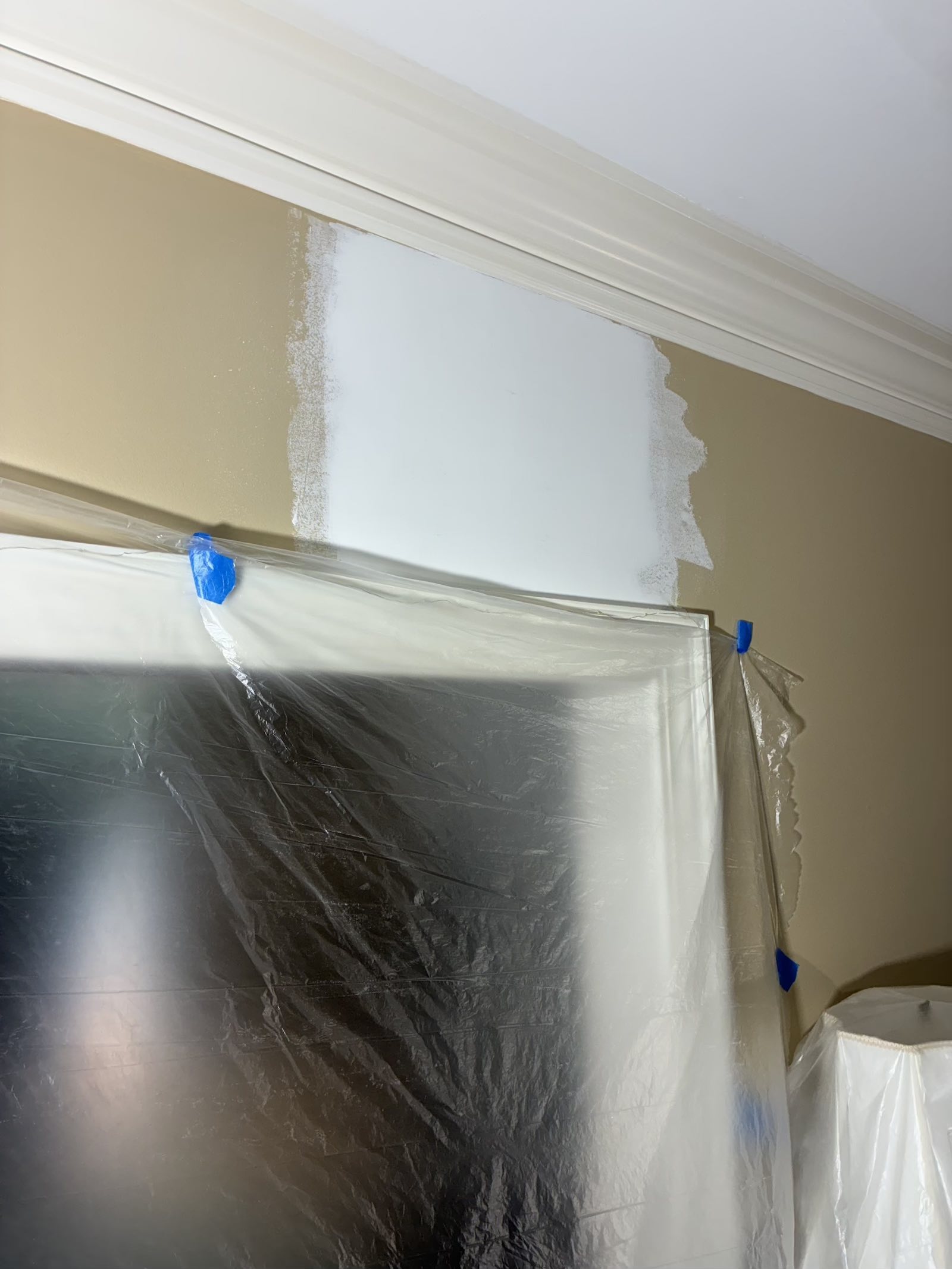 Repaired drywall joint above a door viewed from an alternate angle before priming and painting