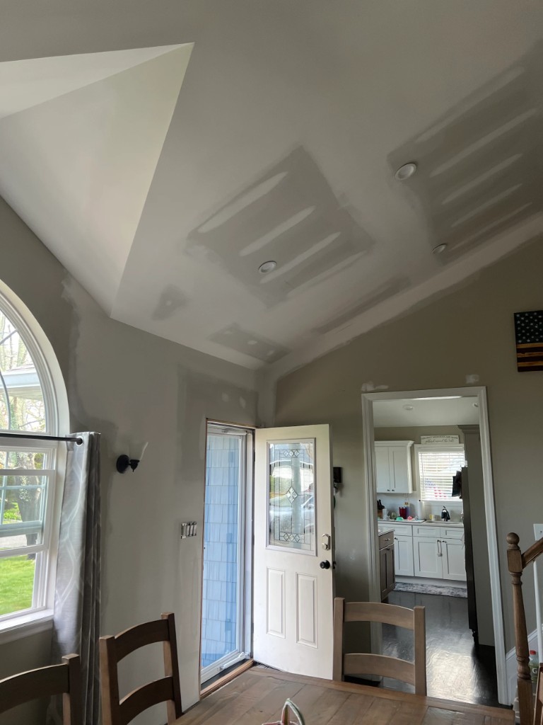 Vaulted ceiling and walls with joint compound on seams and patches before interior painting