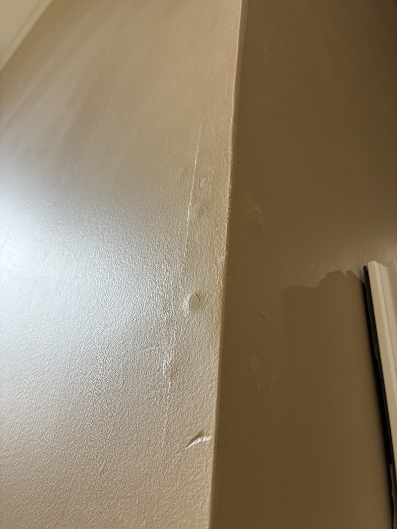 Cracked outside corner bead on a drywall wall before repair